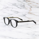 An image of the GR16 Round Opticals in Black frame side view with arms open marble background