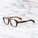 An image of the GR15 Aviator Opticals in Multi Havana frame side view with arms open marble background