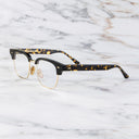 An image of the 0004 Kingsman Round Opticals in Black/Havana frame side view with arms open marble background