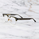 An image of the 0004 Kingsman Round Opticals in Olive frame side view with arms open marble background