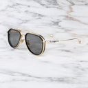 An image of the Cutler and Gross The Great Frog Limited-Edition Triumph Aviator Sunglasses in Gold/Black frame side view with arms open marble background.