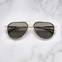 An image of the Cutler and Gross The Great Frog Limited-Edition Triumph Aviator Sunglasses in Gold/Black frame frontal view with arms closed marble background.