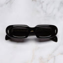 An image of the The Great Frog Rapture Limited Edition Rectangle Sunglasses in Black frame frontal view with arms closed marble background 