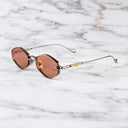 An image of the Cutler and Gross The Great Frog Carol Rectangular Sunglasses in gun metal/gold frame side view with arms open marble background.