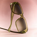 A clickable  image titled as Women's  Sunglasses featuring green oversized sunglasses with brown gradient lenses  and  Shop all button in the bottom left corner, all linking directly to Women's Sunglasses collection page. 