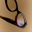 A clickable  image titled as Women's Opticals featuring black oval optical frame and  Shop all button in the bottom left corner, all linking directly to Women's Opticals collection page. 