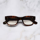 An image of the 0868 Kingsman Optical Square Glasses in Dark Turtle frame frontal view with arms closed marble background 