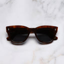 An image of the 0935 Kingsman Square Sunglasses in Ground Cloves frame frontal view with arms closed marble background 