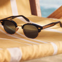 Close up image of the Breitling Biarritz 0003 Round Sunglasses Limited Edition frames on a deck chair.