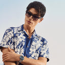Image of male model wearing Breitling Cloudbreak 0004 Rectangle Sunglasses in Dark Grey, with his arms folded. 