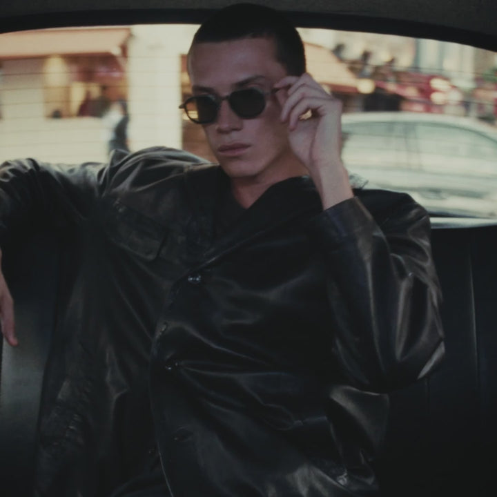 A video of a male model wearing Cutler and Gross Black frame in a back of a London black cab.